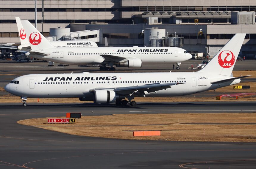A Japan Airlines Boeing 767-346ER on the ground with two other Japan Airlines aircraft behind it.