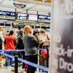 A group of people standing in line at an airport