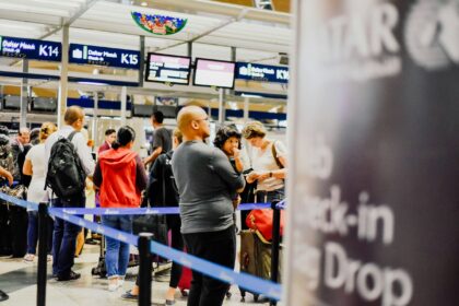 A group of people standing in line at an airport