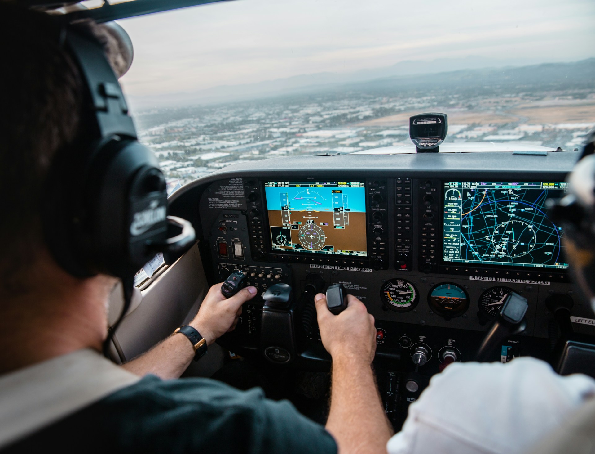 A pilot in the cockpit navigating a flight mid air