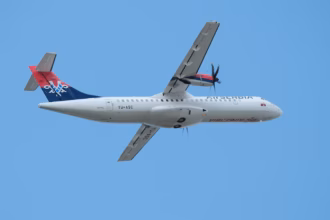 Air Serbia plane travelling East in the background of a bright blue sky