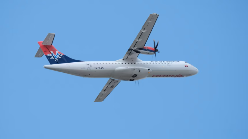Air Serbia plane travelling East in the background of a bright blue sky