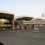 The exterior of King Khalid International Airport in Riyadh, a car can be seen parked just outside of the building.