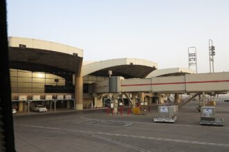 The exterior of King Khalid International Airport in Riyadh, a car can be seen parked just outside of the building.