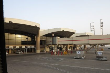 The exterior of King Khalid International Airport in Riyadh, a car can be seen parked just outside of the building.