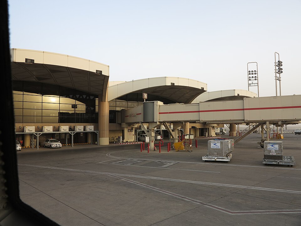 The exterior of King Khalid International Airport in Riyadh, a car can be seen parked just outside of the building.