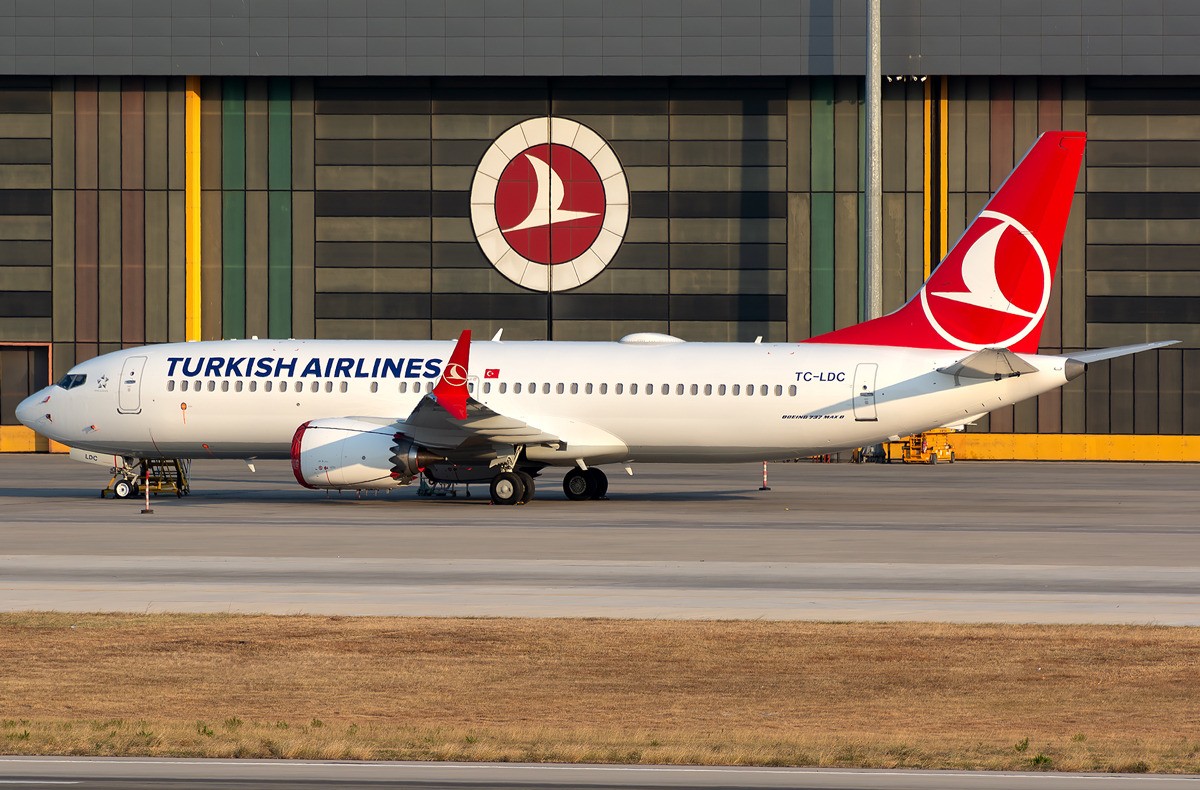 Turkish Airlines Boeing 737 MAX 8 parked on an apron in front of a hangar.