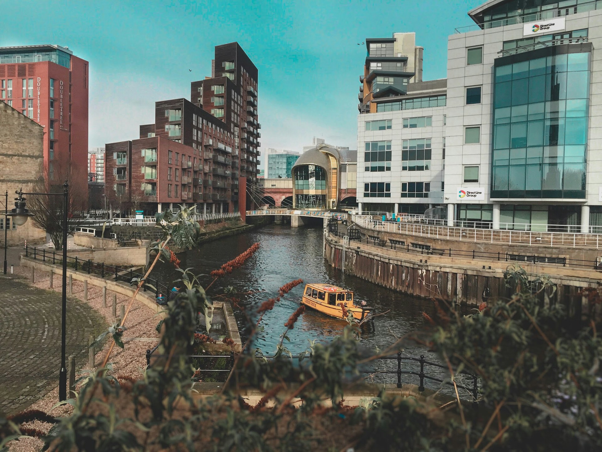 A yellow boat on a body of water with buildings in the background in Leeds
