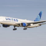 A United Airlines Boeing 767 pictured mid-flight with a blue sky in the background.