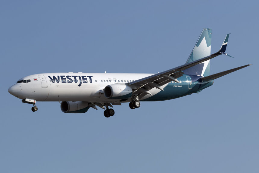 A WestJet Boeing 737 mid-flight with a blue sky as the background.