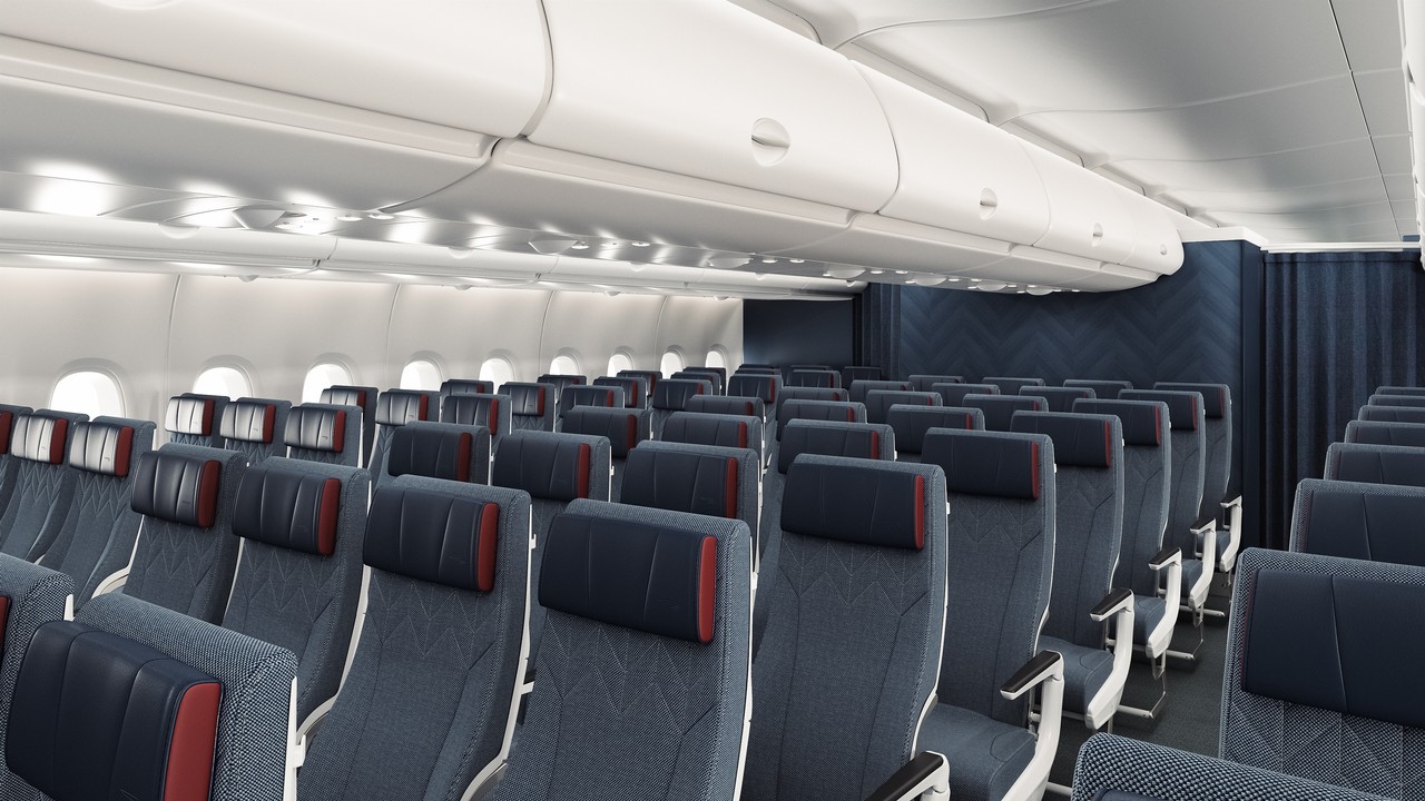 The new World Traveller cabin on the A380 retrofit. Designed with British Airways branding in mind, it has deep grey seats with navy and red accents. The pillows are trimmed with a deep royal red, and the back walls are a zigzag pattern coloured in a dull midnight blue. The rest of the cabin is a typical bright white where storage is.